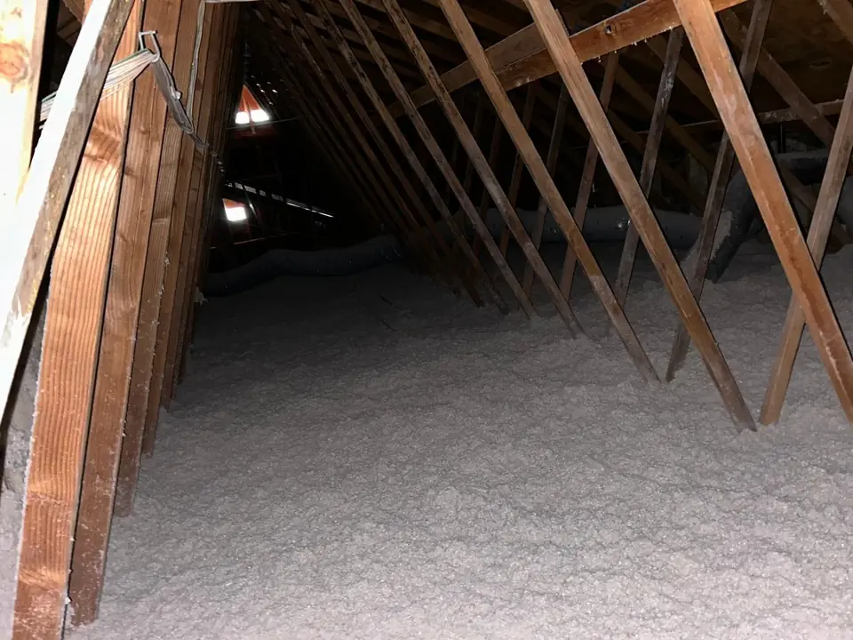 Attic with fresh blown-in cellulose insulation under the rafters