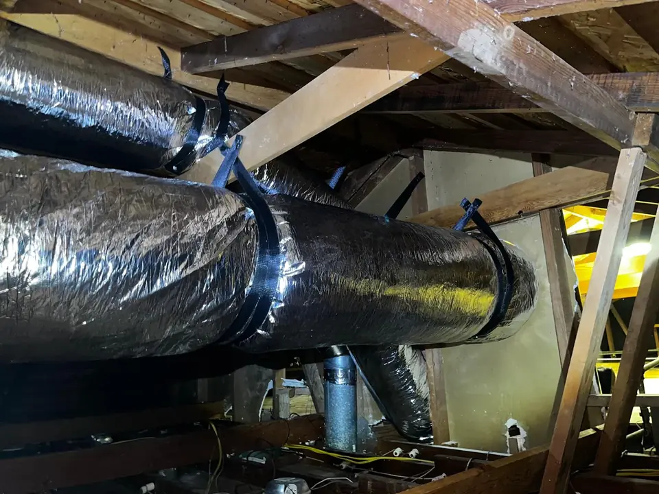 New silver flexible insulated ducts installed along the framing